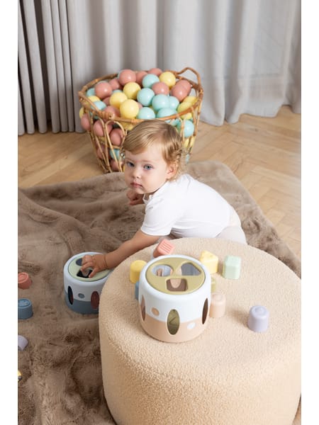 LyseblĂĄ puttekasse med pastelfarvet geometriske klodser til at sortere og putte i huller.